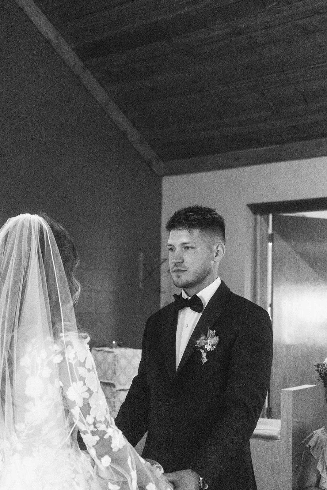 A bride and groom face each other in front of a priest during a ceremony in a church in Gardiner, Montana