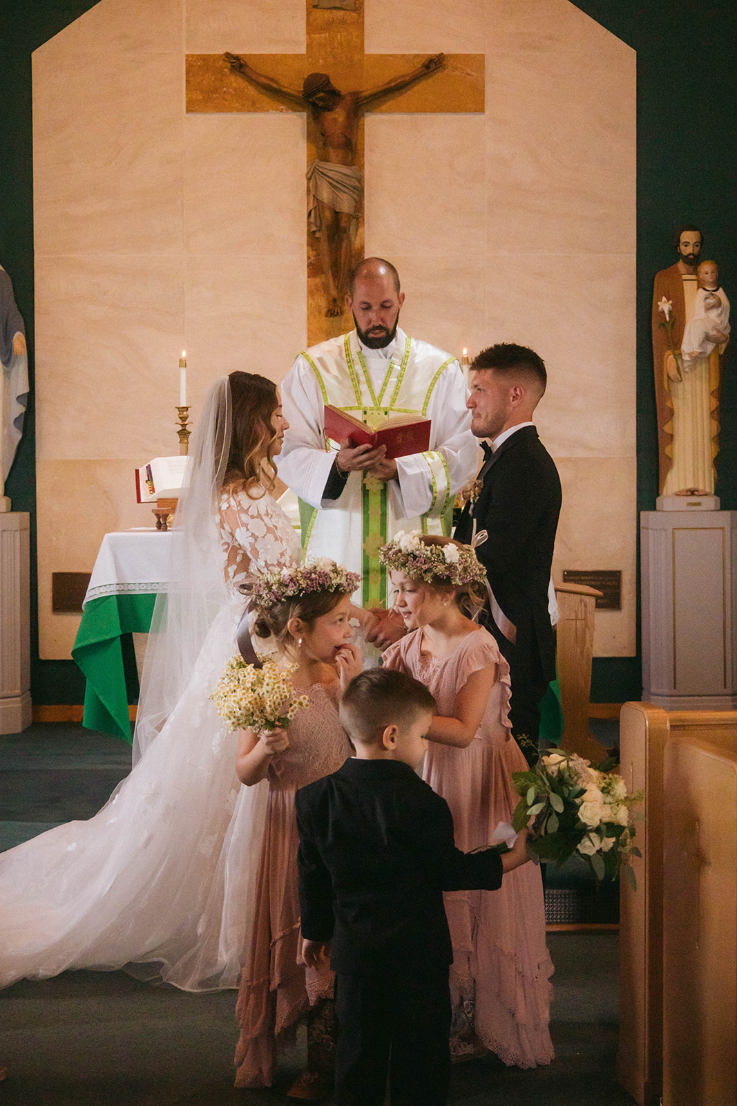 A bride and groom face each other in front of a priest during a ceremony in a church in Gardiner, Montana